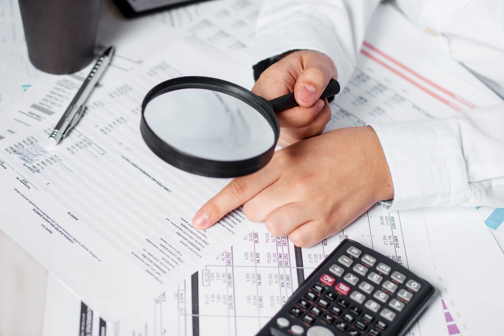 Businessman using magnifying to review balance sheet annual. Concept of Internal audit, Auditing tax, Analyze return on investment.